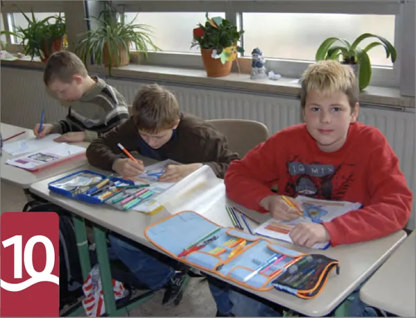 Kinder malen und zeichnen an Schultischen